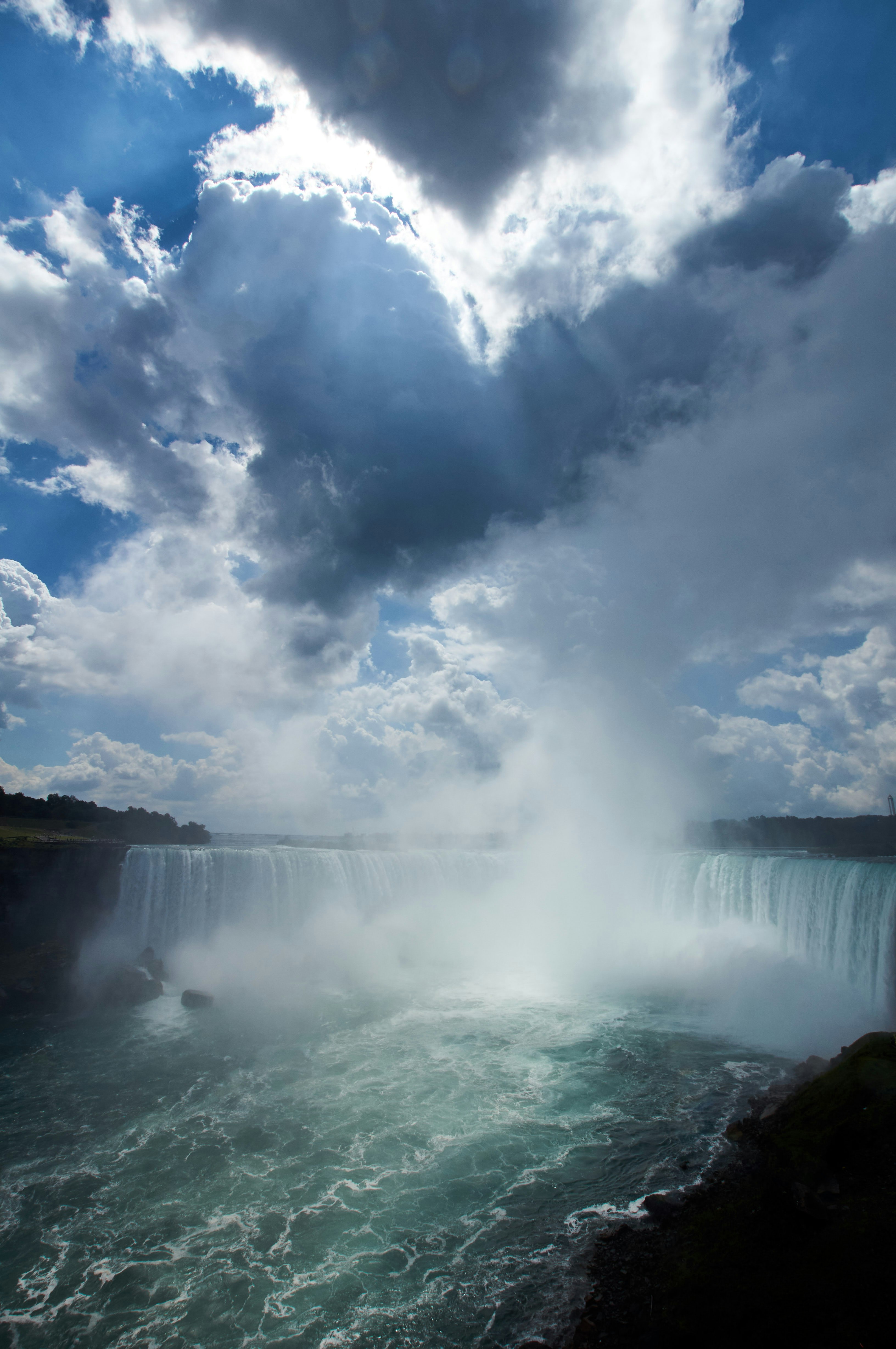 waterfalls under blue and white cloudy sky during daytime